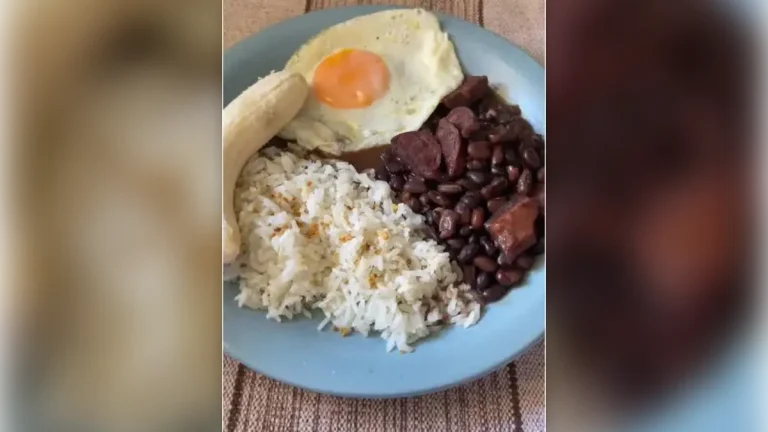 Arroz, feijão preto e ovo frito: receita caseira fácil Arroz, feijão preto com linguiça, ovo frito e banana em prato azul
